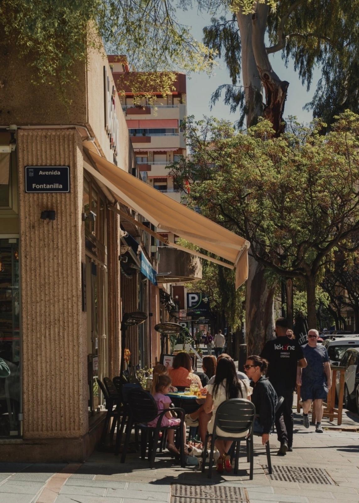 Terraza de Lekune en Avenida Fontanilla, Marbella, con mesas ocupadas al sol