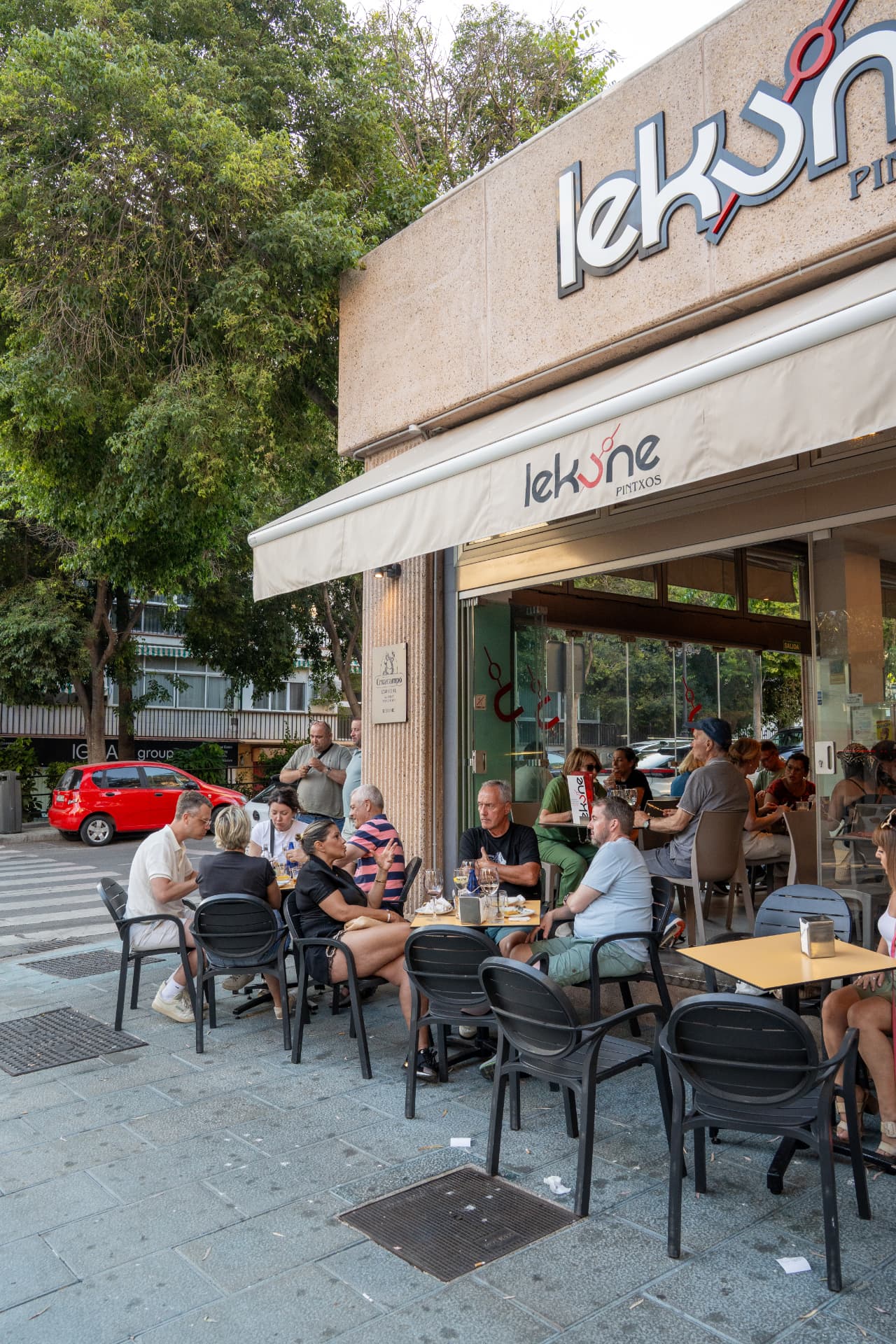 Terraza de Lekune en Avenida Fontanilla, Marbella, con mesas ocupadas al sol